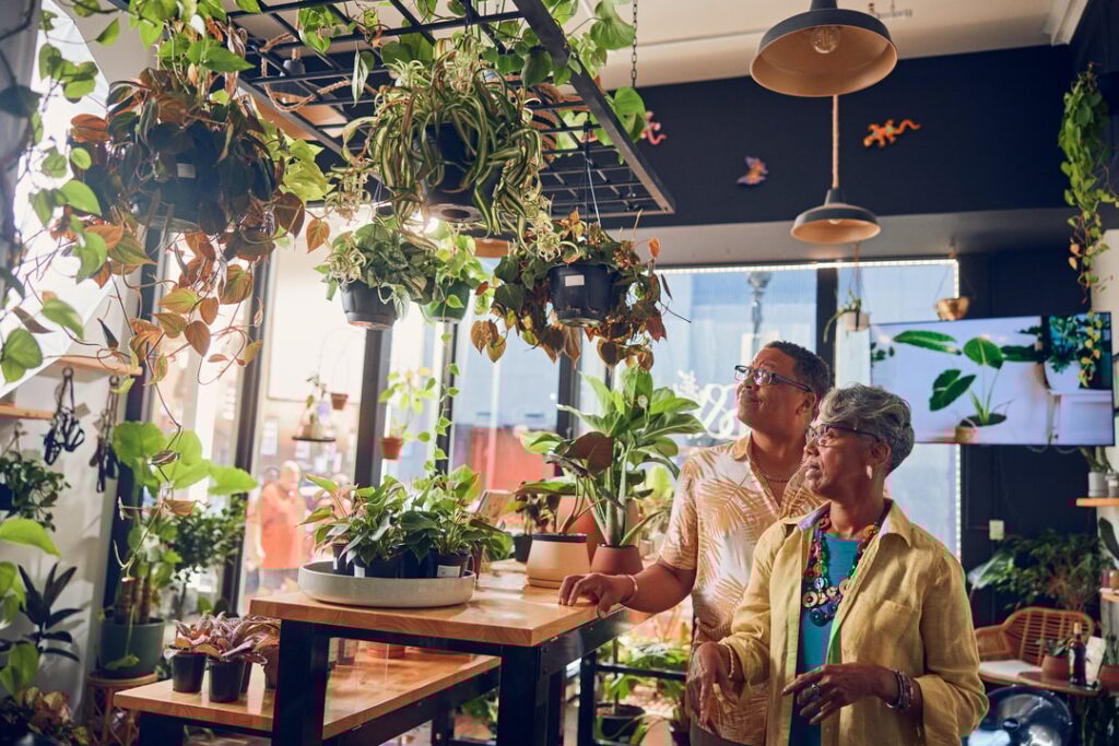 a Black couple walk around a plant store