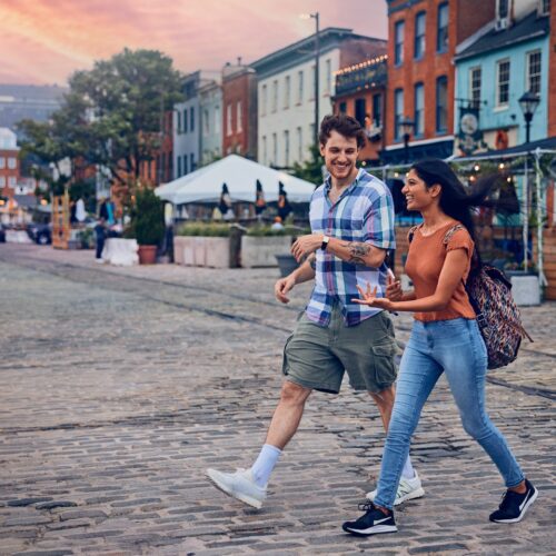 two people crossing the street in fells point