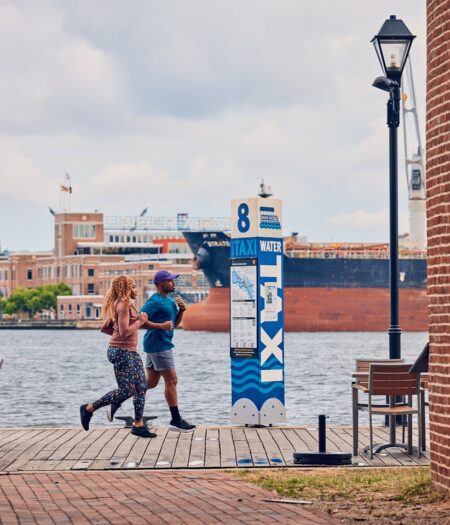 Two people running along the water
