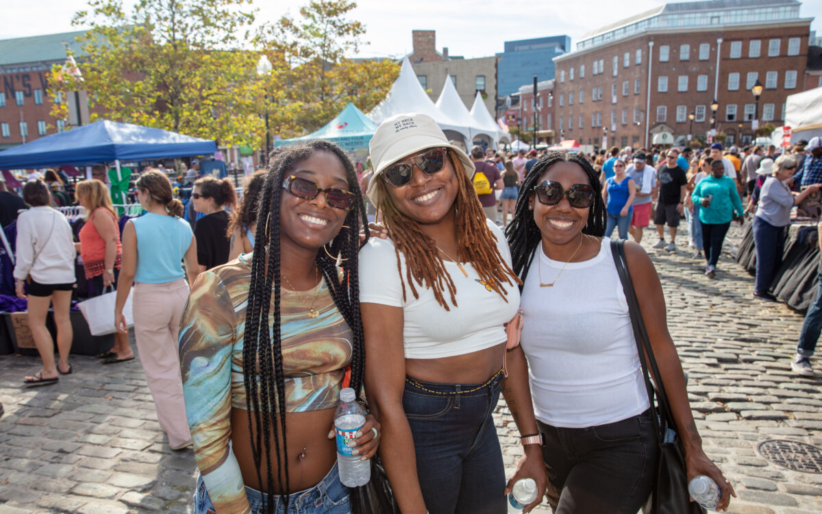 three women smile for a photo in Fell's Point