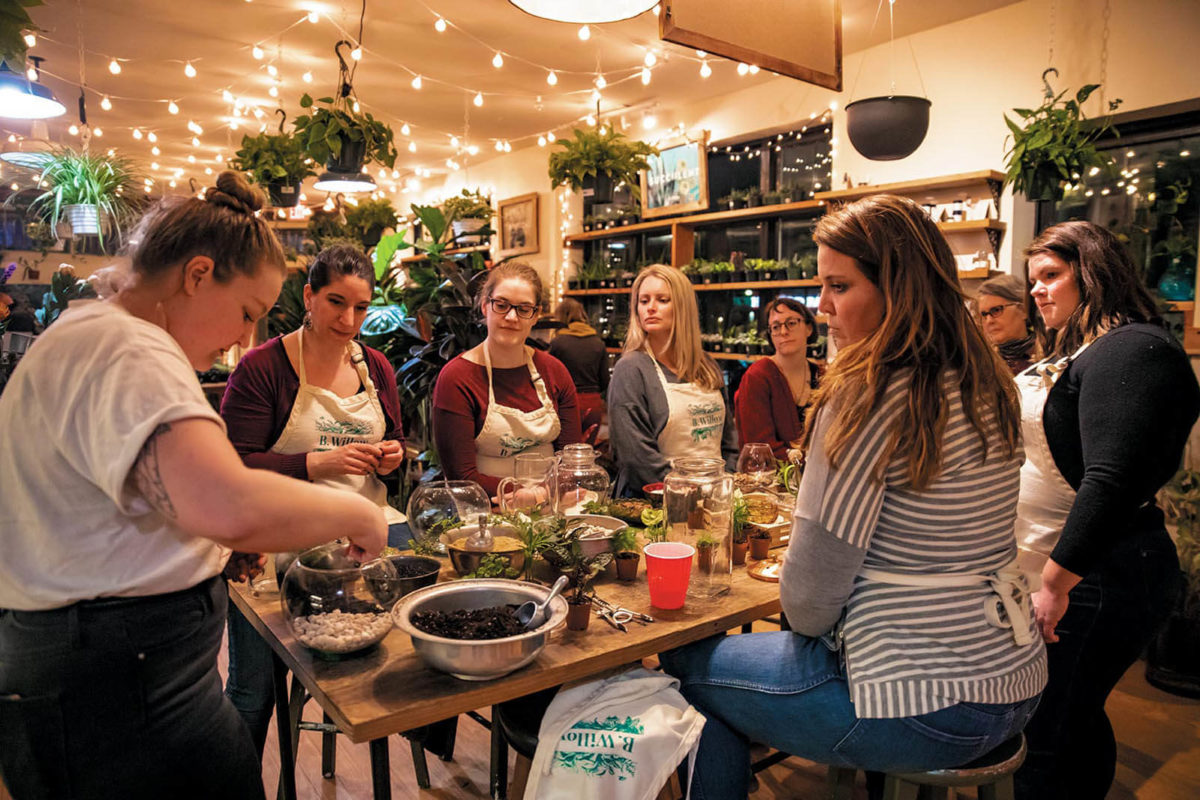 Students sit around a table making plants during a class at B Willow Store in Baltimore.