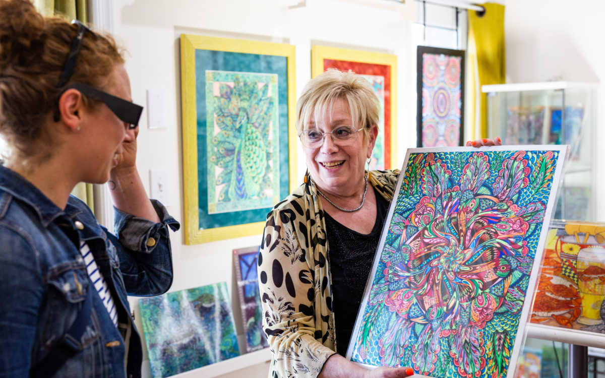 Artist Debbie Lynn Zwiebach shows off a painting