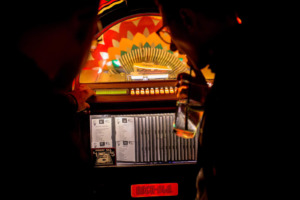 Customers with drinks in front of the juke box at Club Charles cocktails in Baltimore, Maryland.