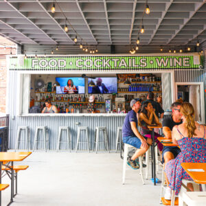 People sitting at high-top bars in an outdoor patio