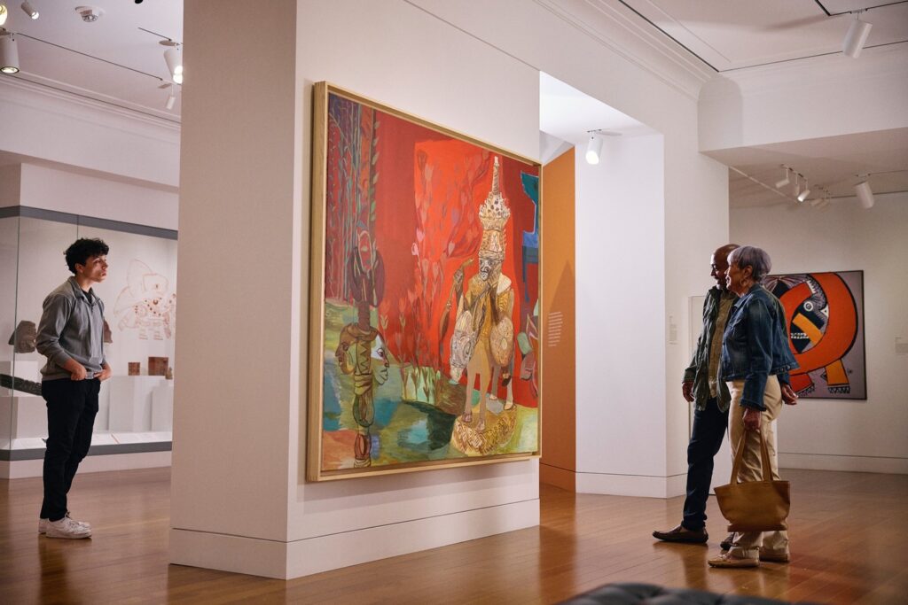 Two people look at large art work on the wall