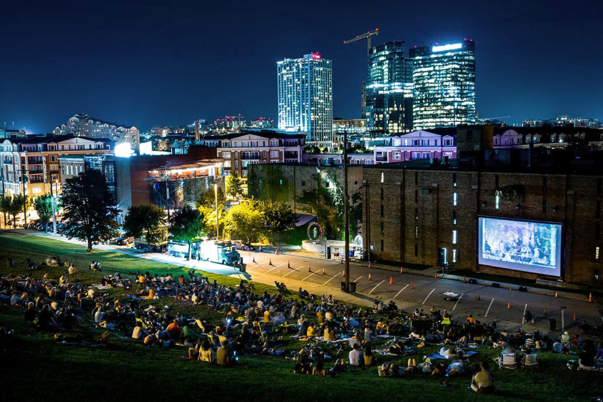Folks watch movies on the hill at night at AVAM in Baltimore.