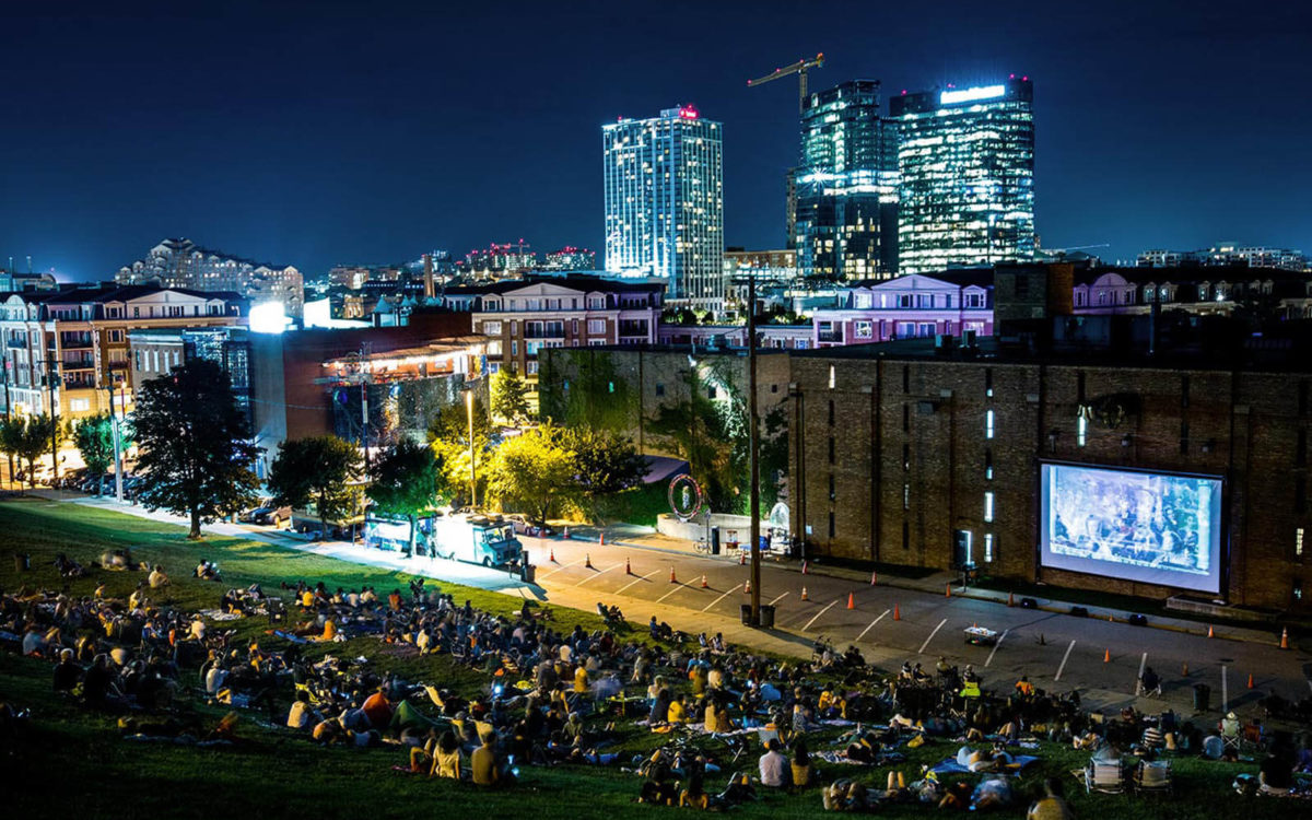 Folks watch movies on the hill at night at AVAM in Baltimore.