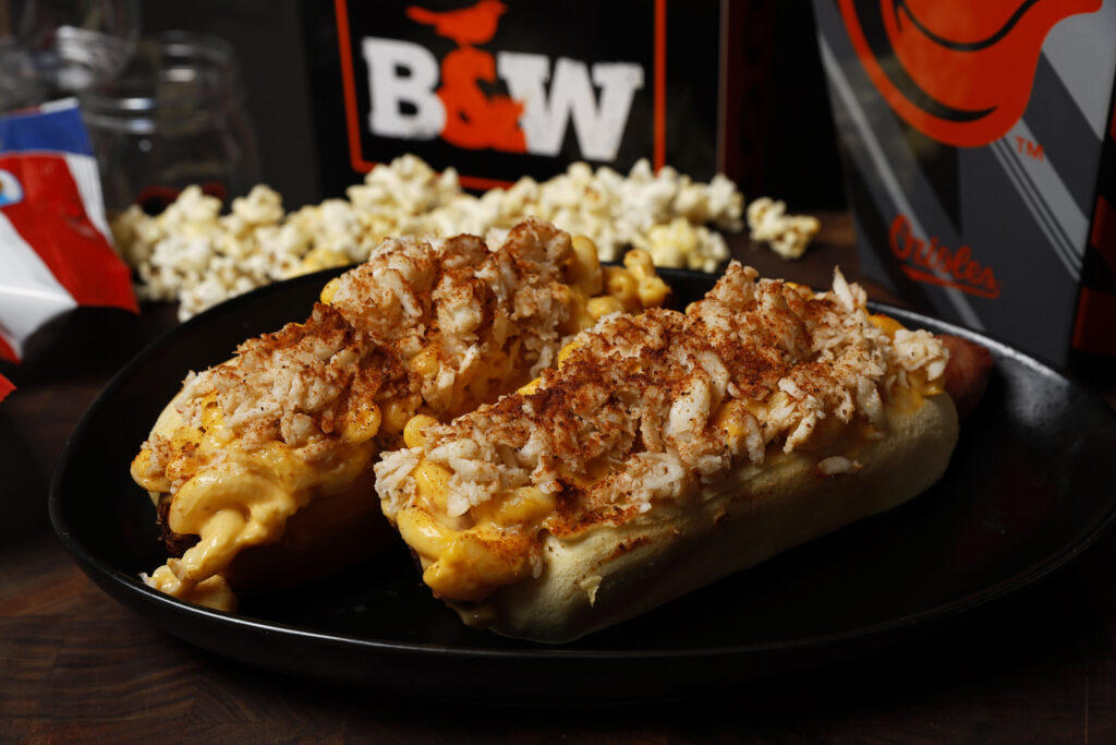 Two hot dogs topped with crab mac and cheese