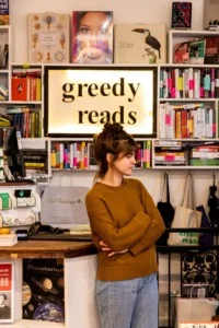Woman, Greedy Reads owner, stands in her bookstore